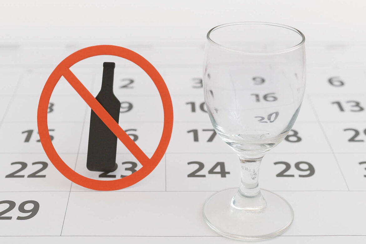 Kalender mit durchgestrichenem Flaschensymbol und leerem Weinglas – Symbol für Alkoholverzicht und Neubeginn